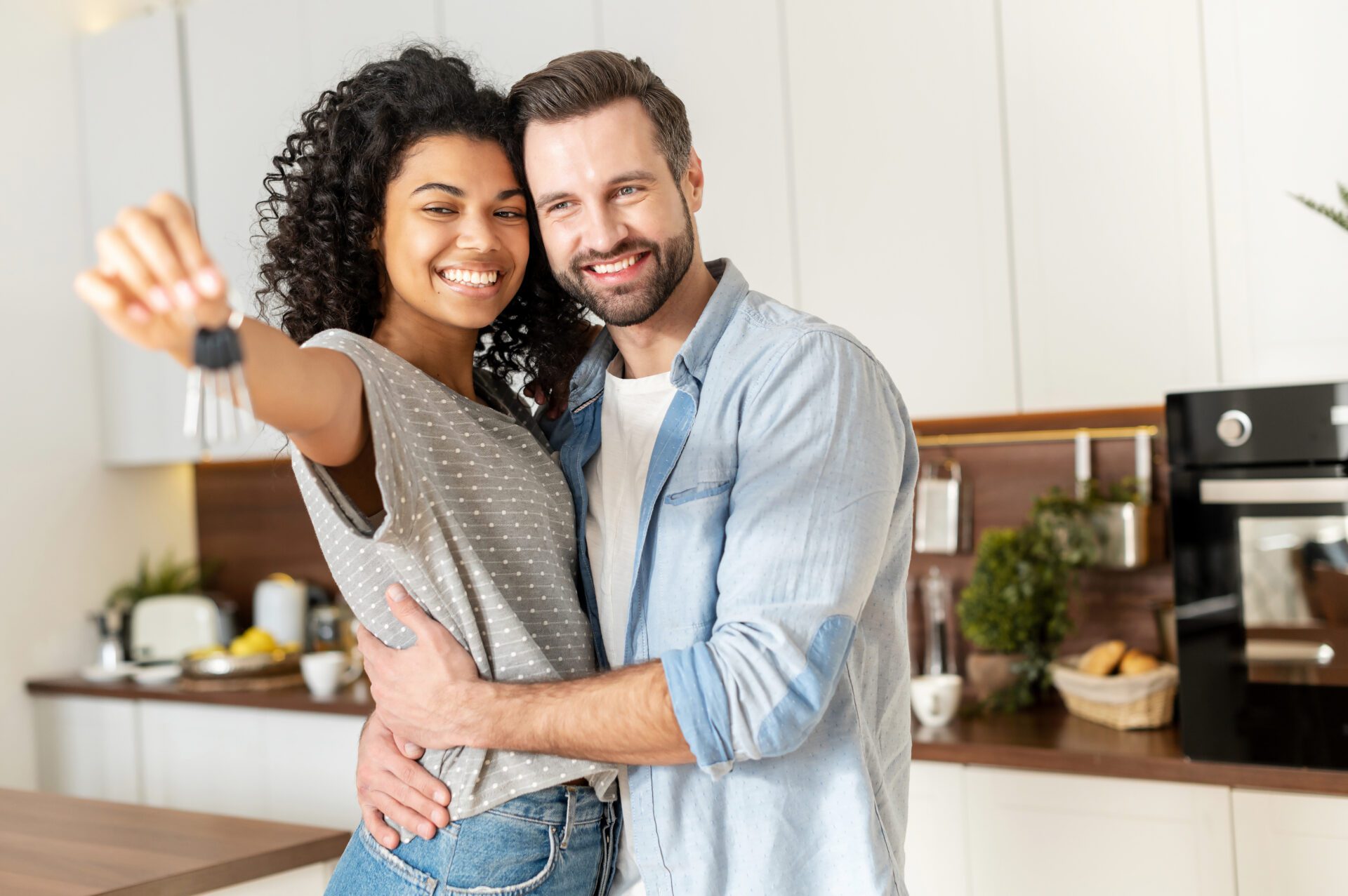 Young Interracial Married Couple Homeowners Smiling Showing Keys From A